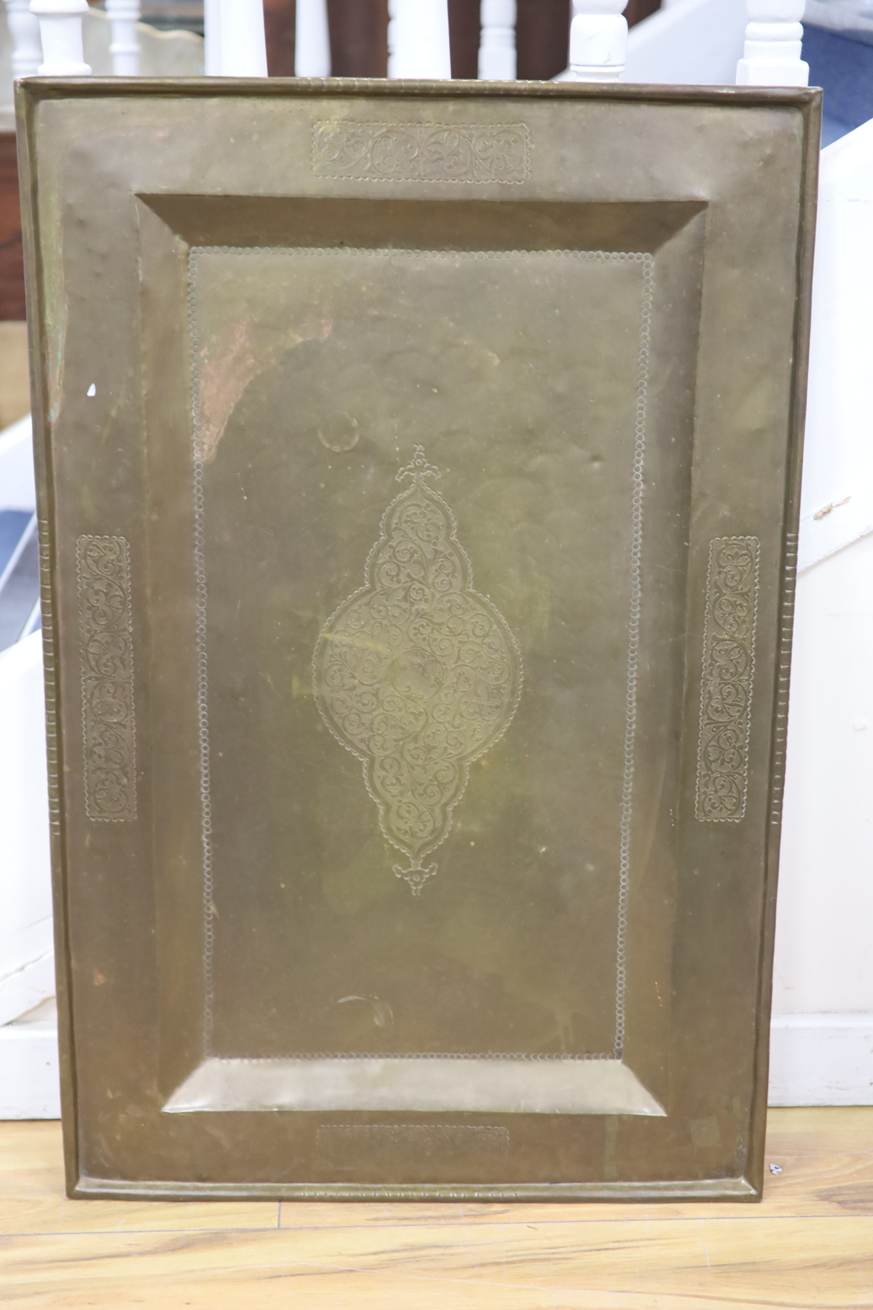 A rectangular Persian engraved brass tray, width 62cm, height 96cm